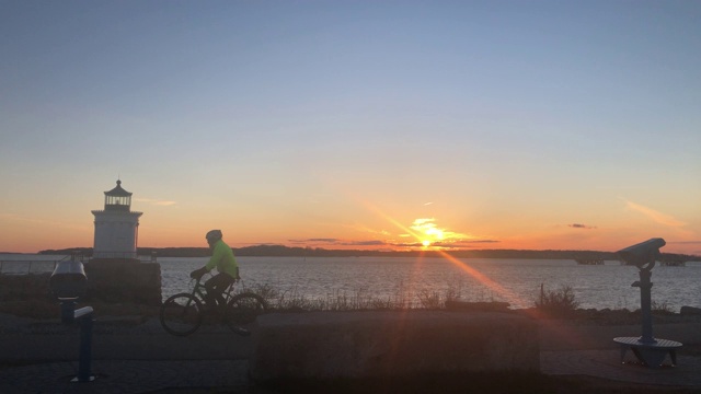 跑步者和自行车手在日出时在美国缅因州波特兰南部的巴德灯塔锻炼视频素材