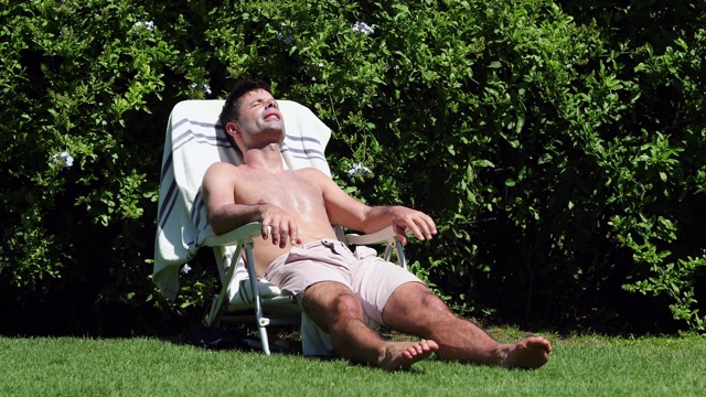 在后院游泳池里晒太阳的男人。随意直率的人在户外晒黑视频素材