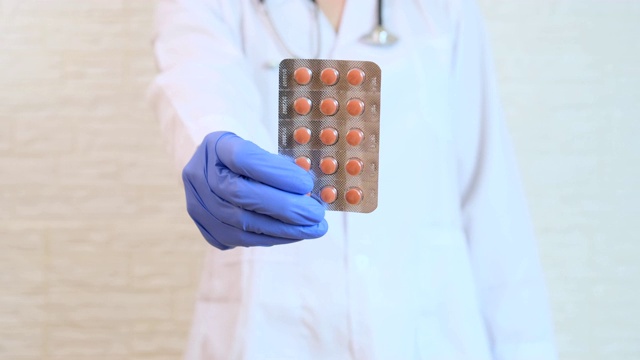 医生在蓝色手套显示红色药丸，胶囊在水泡，疾病的治疗和处方概念视频素材