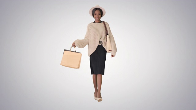 快乐年轻的非洲裔美国女人与购物梯度背景视频下载