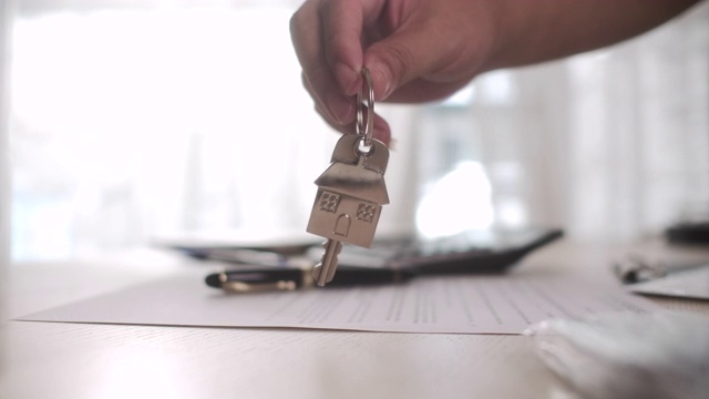 在一个房子形状的钥匙圈上拿着新房子的钥匙视频下载