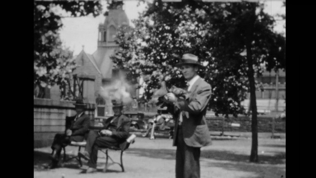 20世纪20年代，肯塔基州刘易斯维尔，一名男子在公园里喂鸽子，鸽子飞到他的手和胳膊上视频下载