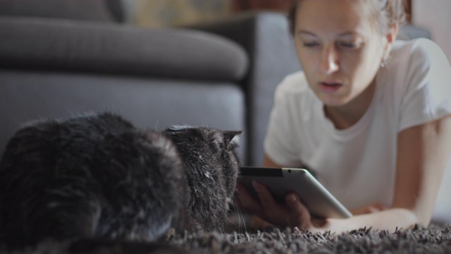 一个女人在和她的宠物玩平板电脑视频素材