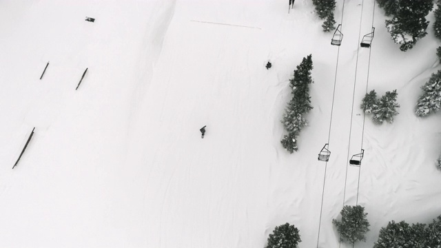 完成一个“后空翻法”的技巧与森林和滑雪升降机在背景在科罗拉多州博尔德附近的埃尔多拉滑雪度假村在一个下雪，阴天视频素材