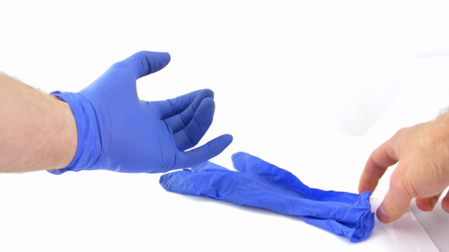 戴上防护蓝色手术手套在白色背景的POV视频下载