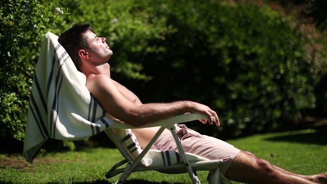 帅哥正在外面休息。躺在户外晒太阳的人视频下载