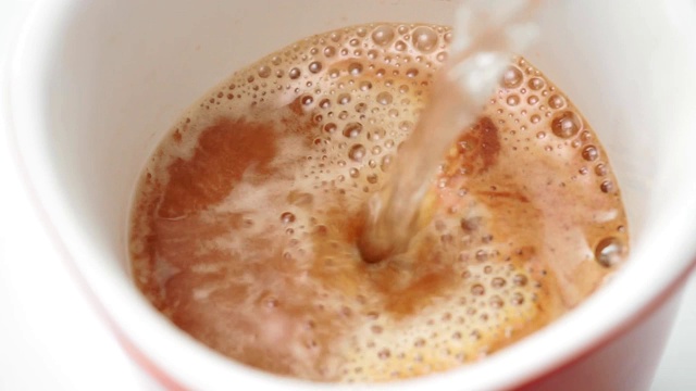 热水的力量变成磨碎的咖啡豆近距离的慢动作。让早晨喝咖啡视频素材