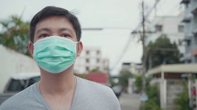 近距离的亚洲年轻男子戴着口罩。视频下载