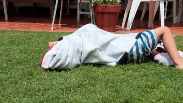 夏天，孩子们裹着毛巾在草地上打滚视频下载
