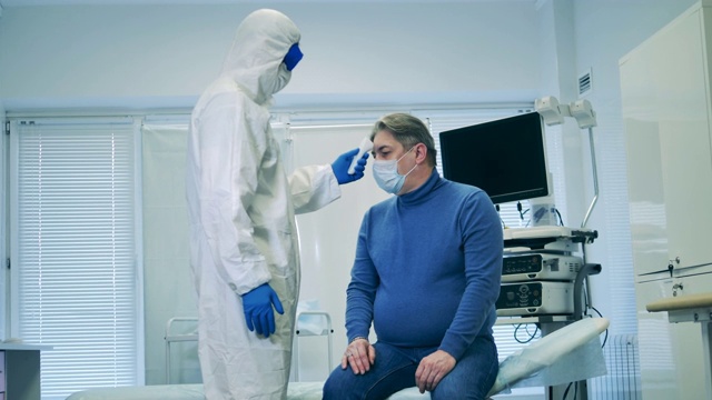 医护人员正在用红外线温度计测量病人的体温。医院冠状病毒诊断医学检测。视频素材