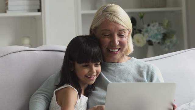 快乐的中年妇女用电脑与孙女。视频素材