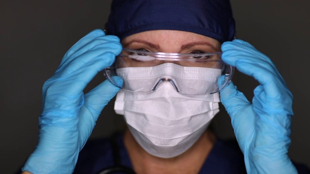 女医生或护士摘掉医用口罩和防护眼镜视频素材
