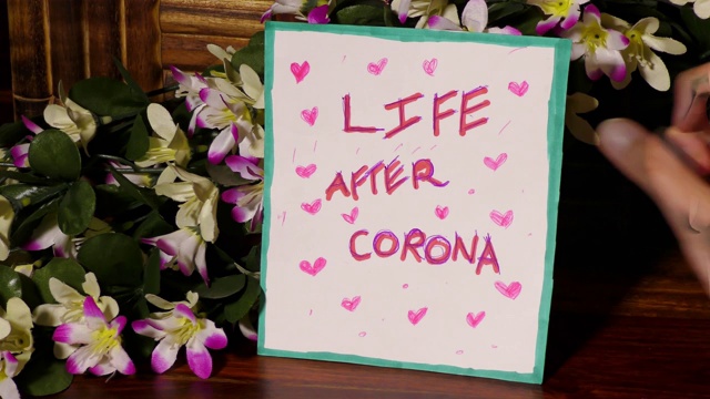 一名女孩在花上张贴“新冠肺炎后的生活”海报视频素材