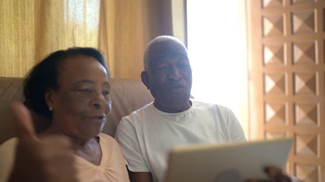 一对老年夫妇在家里用平板电脑视频通话视频素材