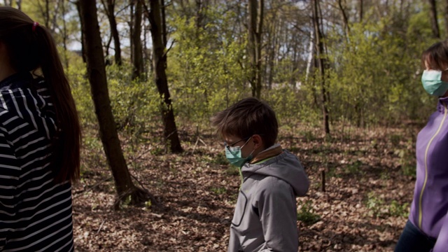 2019冠状病毒病大流行期间，家人在森林里散步视频素材