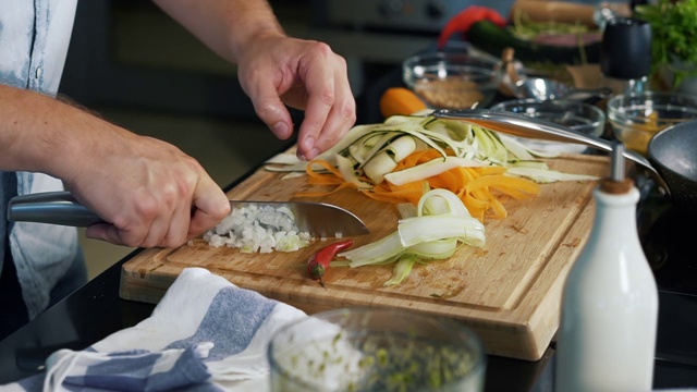 男厨师，以快速专业的动作，把洋葱切成小块，拿起辣椒，切它，锋利的刀，明确的动作，烹饪，成熟的蔬菜，厨师从餐厅，配料视频素材