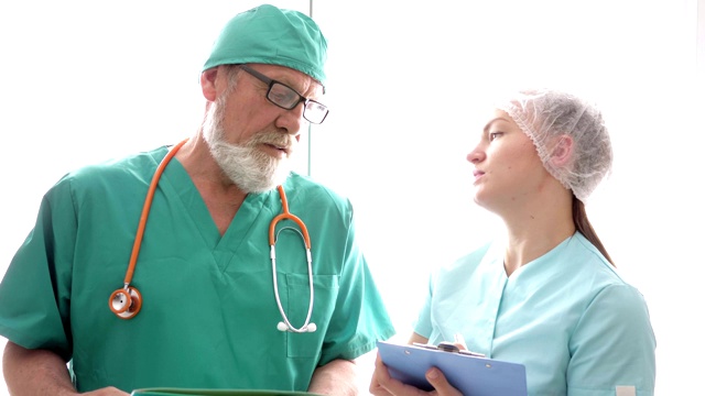 一位年长的医生给一位年轻的护士指路视频下载