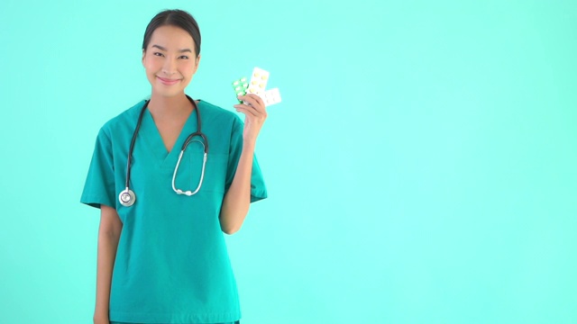年轻的亚洲女性与药物或药物在蓝色孤立的背景视频下载