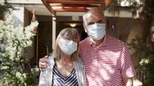 2019冠状病毒病隔离期间，一对老年夫妇站在家门口视频素材