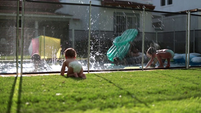 孩子们在游泳池里玩。婴儿观察儿童在自家后院的泳池水内玩耍视频素材