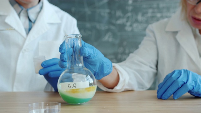 化学家在实验室混合物质时观察化学反应视频下载