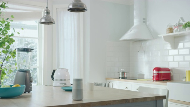 舒适的现代斯堪的纳维亚厨房室内电器和水果。空荡荡的阳光房，木桌上有无线扬声器、咖啡机、水壶和烤面包机。冬天的雪。视频素材
