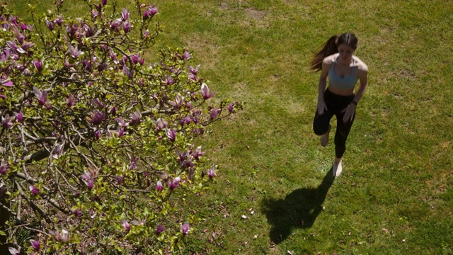 一名年轻女子在禁闭期间在家花园里锻炼视频下载