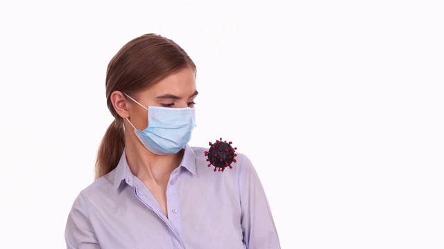 戴医用口罩的妇女被COVID-19病毒细胞吓到视频素材