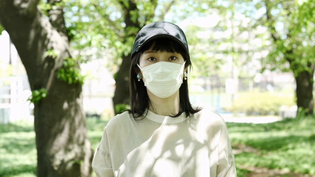 户外肖像亚洲妇女戴着外科口罩视频素材