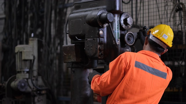 橙色制服的技术员在工厂维护和解决机器的问题视频素材