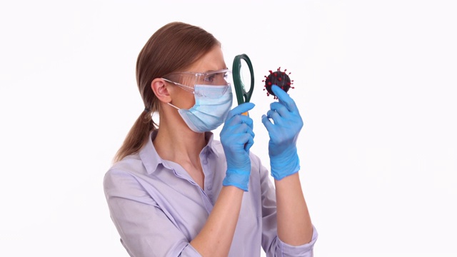 年轻女医生用放大镜研究COVID-19病毒分子视频素材