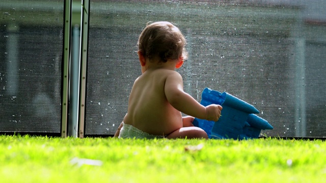 家庭在游泳池，婴儿婴儿在前景和孩子在水中玩耍的背景视频素材