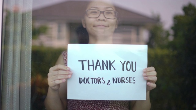 妇女在家里表示感谢医生和护士，鼓励医生和护士应对新冠肺炎疫情视频下载