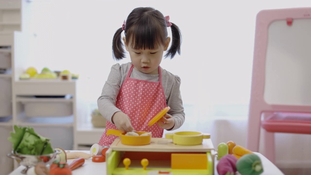蹒跚学步的小女孩假装玩准备食物的游戏视频下载