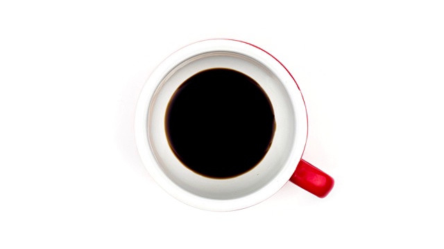 俯视图停止运动咖啡倒在杯子孤立的白色背景。视频下载