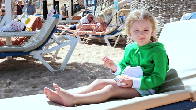 小女孩在海滩上吃冰淇淋。视频下载