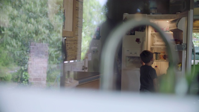 小男孩在冰箱里找零食。视频下载