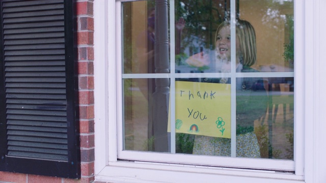 小女孩用自制的感谢签名欢迎家庭护士。视频下载