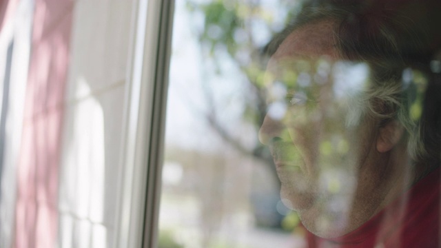 SLO MO. CU的大个子男人悲伤地看着窗外。视频素材