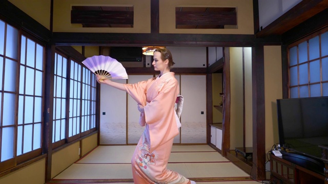 穿着和服的俄罗斯妇女用折扇表演日本舞蹈视频下载