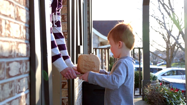 一个可爱的红发小孩把自制的面包送到邻居家视频下载