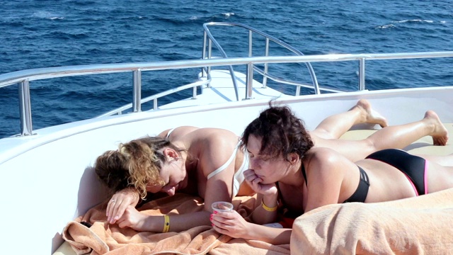 两个女人在游艇上晒日光浴。视频素材