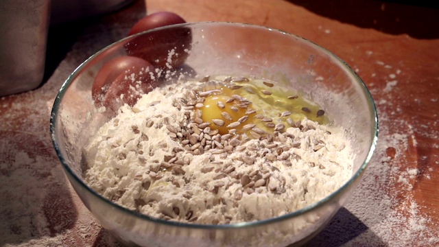 女主人用面粉、鸡蛋和葵花籽做了一个生面团视频素材