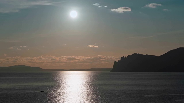 日落时分，克里米亚的卡拉达格山脉和小船上的渔民令人难以置信的美景视频下载