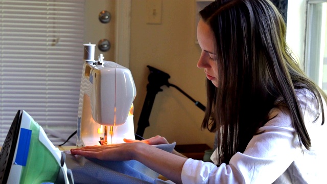 妇女在使用缝纫机时集中注意力视频下载