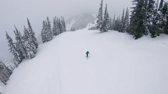 无人机飞离在大雪中徒步登山的人视频下载
