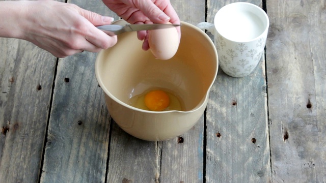 女孩把鸡蛋打到碗里。准备烘焙原料。视频素材