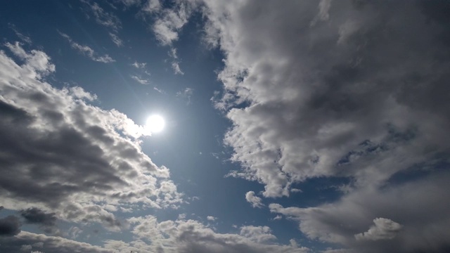 时间流逝:阳光穿过蓬松的云在天空中飞行。晴朗的白天。4 k视频素材