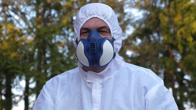 一个穿着防流感服的人向后站着双手的视频视频下载