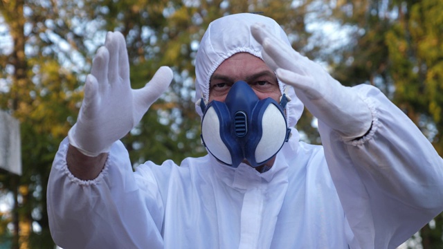 一个穿着防流感服的人向后站着双手的视频视频下载